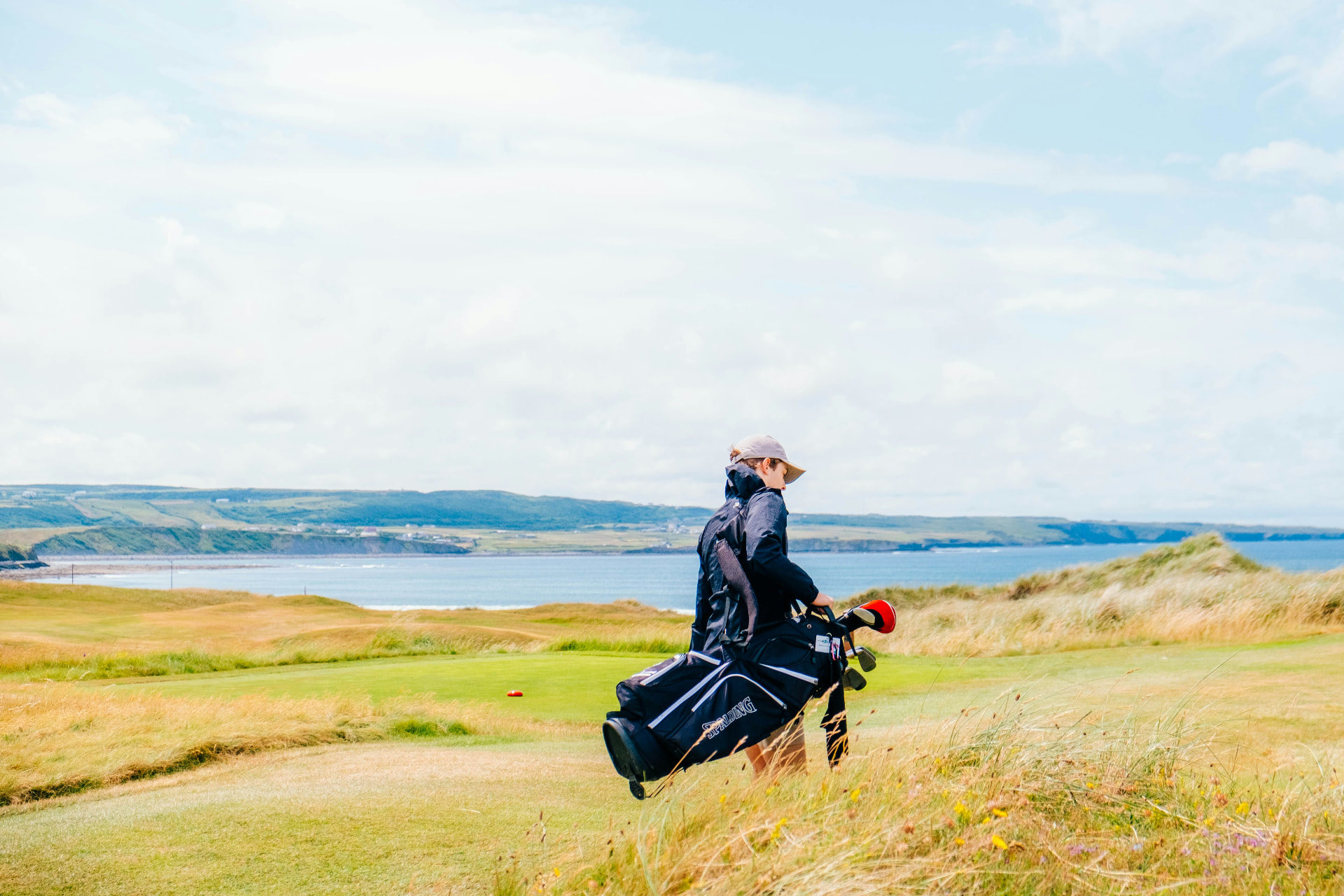 Golfer walking across coastal links in Ireland